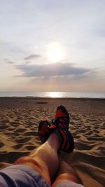 Low section of man relaxing on beach