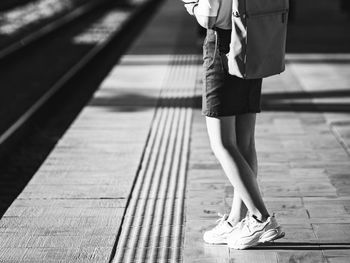 Low section of woman walking on footpath