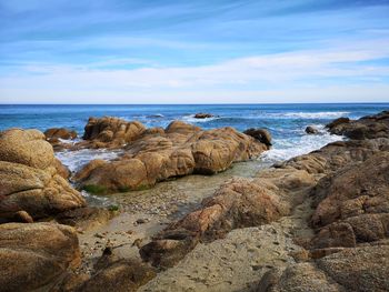 Rocks on beach against sky