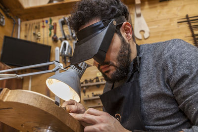 Side view of carpenter working in factory