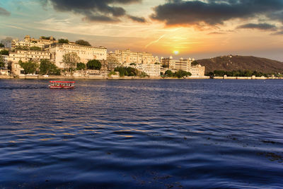 Scenic view of sea by city buildings against sky