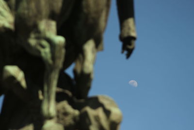 Low angle view of moon against blue sky