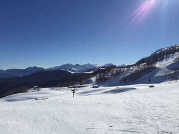 Scenic view of snowcapped mountains against clear blue sky