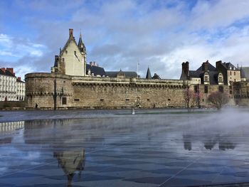 Buildings at waterfront against cloudy sky castle of the dukes of brittany