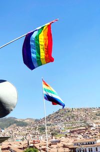 Multi colored flag against blue sky