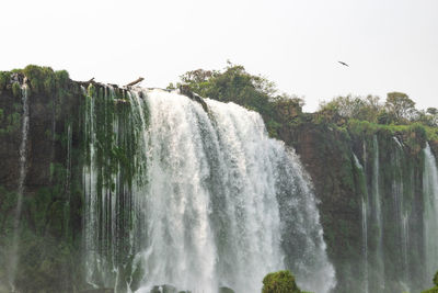 Scenic view of waterfall against sky