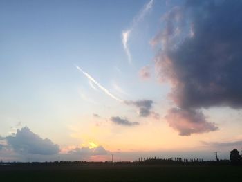 Scenic view of silhouette field against sky during sunset