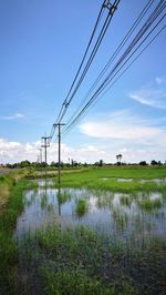 Electricity pylon on field against sky