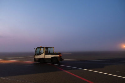 Vehicles on road at sunset