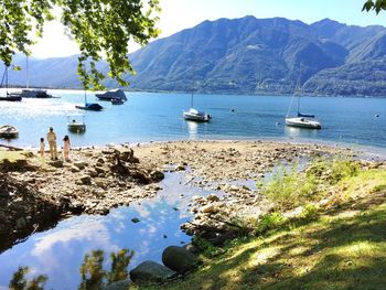 Boats in sea with mountains in background