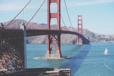 Golden gate bridge over river against sky in city