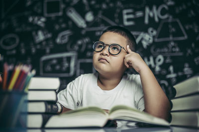 Portrait of boy sitting on book