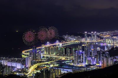 Firework display over illuminated buildings in city at night