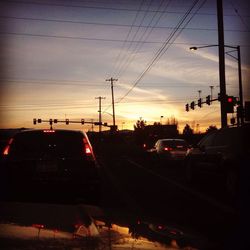 Cars on road against sky during sunset