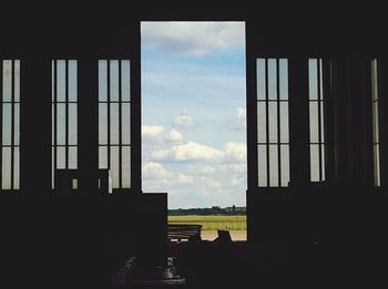 Silhouette trees against sky seen through window