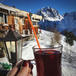 Midsection of person holding ice cream in mountains