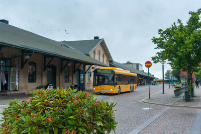 Street by buildings in city against sky