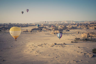 Hot air balloons flying against sky during sunset