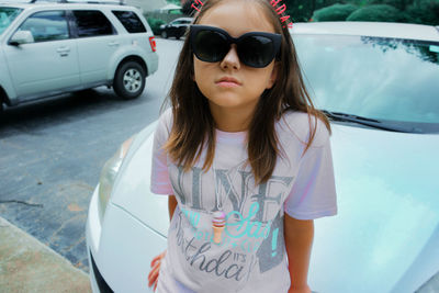 Cute girl standing by car outdoors