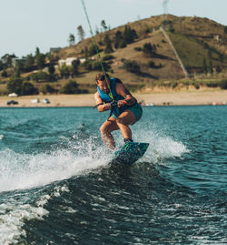 Full length of man wakeboarding in sea