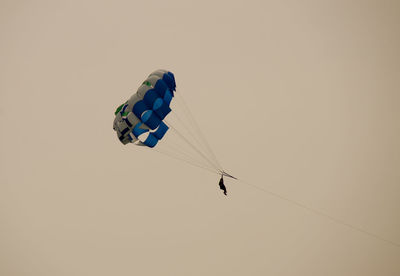 Person parasailing against clear sky