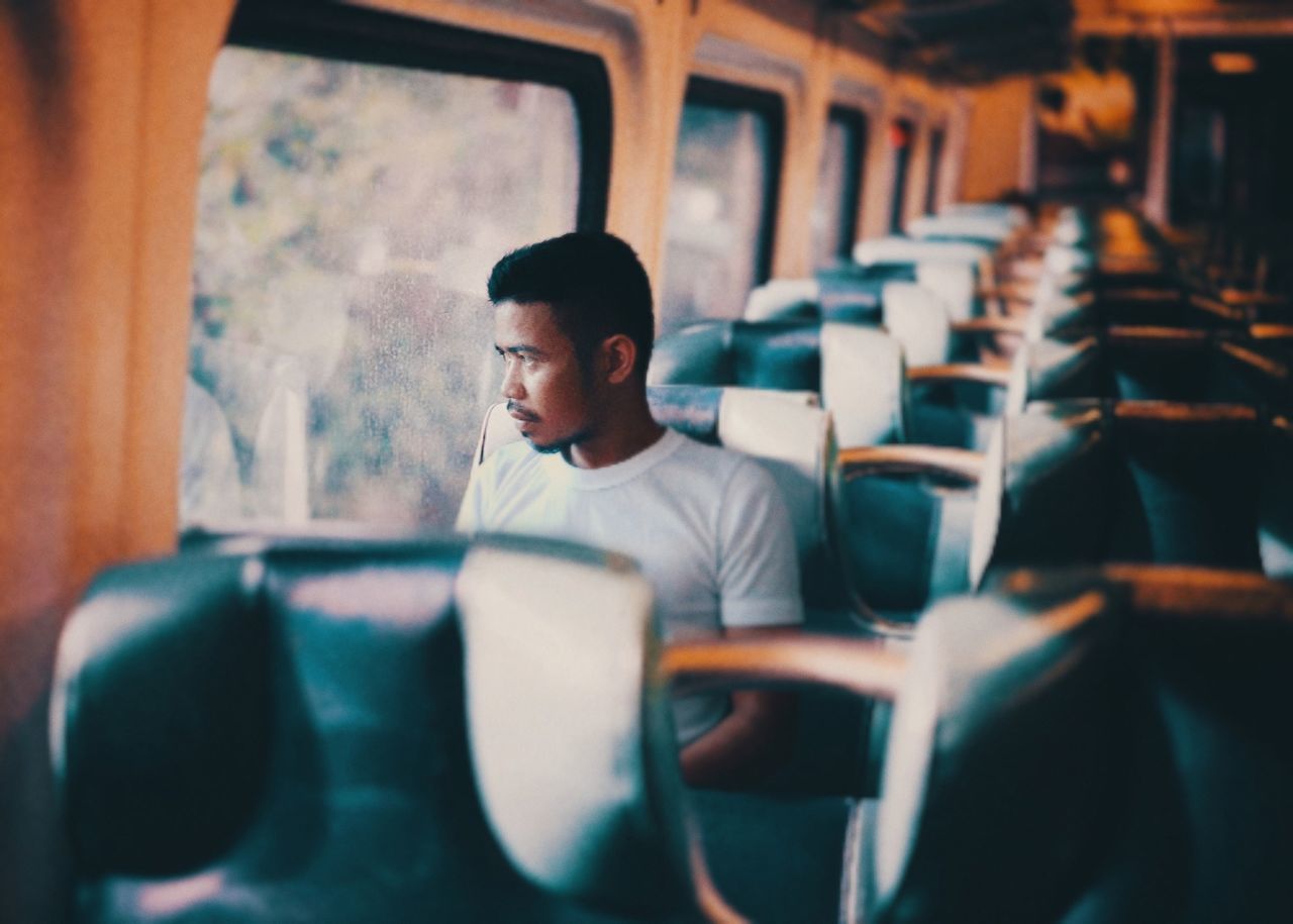 one person, real people, seat, sitting, young adult, men, leisure activity, vehicle interior, mode of transportation, indoors, young men, casual clothing, lifestyles, selective focus, looking, chair, vehicle seat, transportation, waist up, contemplation