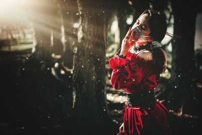 Woman with red umbrella standing outdoors