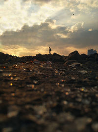 Surface level of beach against sky during sunset