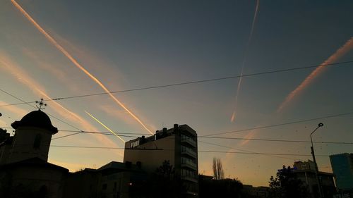 Low angle view of silhouette buildings against sky at sunset