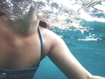 Cropped image of woman swimming in sea