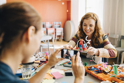 Portrait of happy woman sitting on table