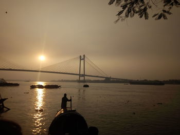 Silhouette of suspension bridge over river