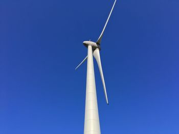 Low angle view of windmill against clear blue sky