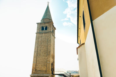 Low angle view of clock tower amidst buildings against sky