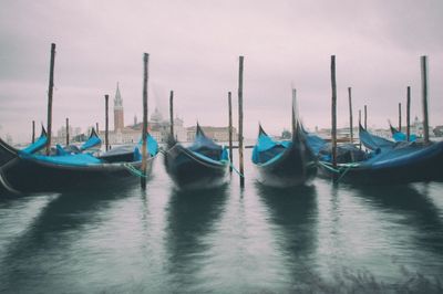 Boats moored in sea against sky