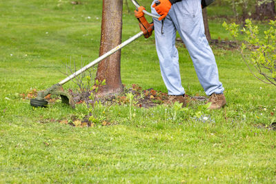 Low section of man standing on grassy field