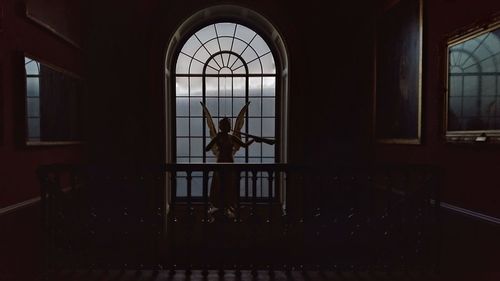 Silhouette man standing by staircase in building