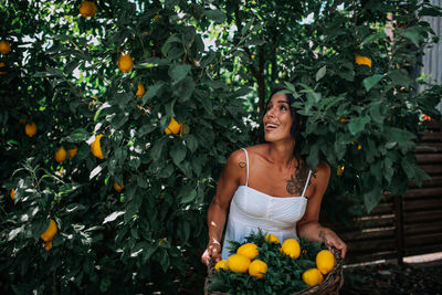 Full length of woman holding orange tree