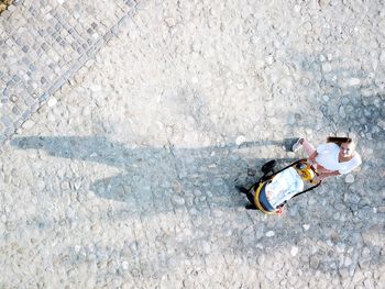 High angle view of woman standing on footpath