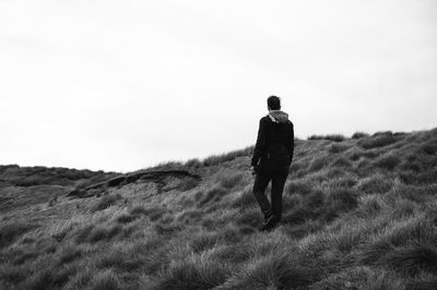 Rear view of a woman walking on field