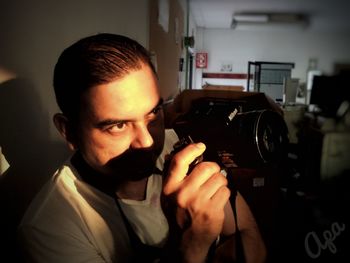 Portrait of young man holding camera