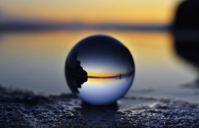 Close-up of crystal ball on beach