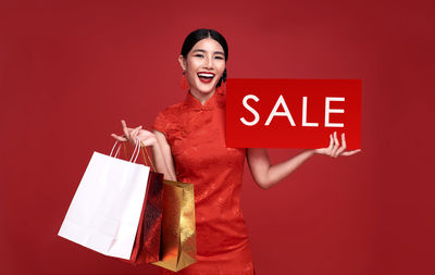 Woman standing against red background