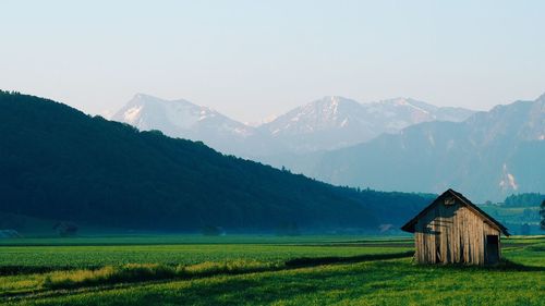 Scenic view of agricultural field by mountains against sky