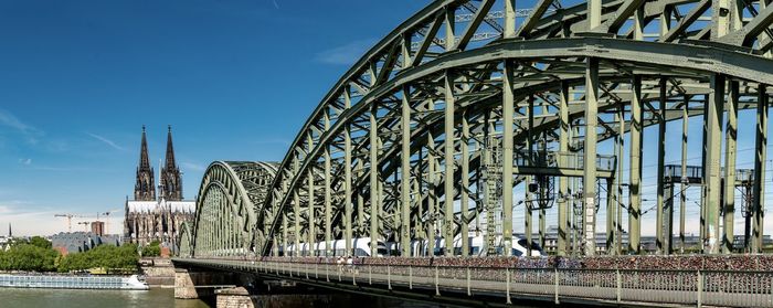 Bridge over river against sky in city