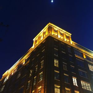 Low angle view of illuminated building against sky at night