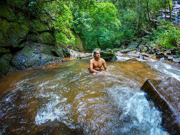 Man bathing in natural waterfall in forests at morning from different angle