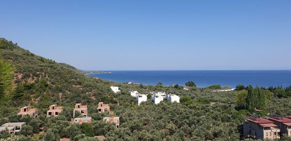 Scenic view of sea and buildings against clear sky