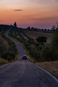 Road amidst landscape against sky during sunset