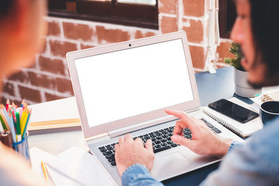 Low section of woman using laptop on table